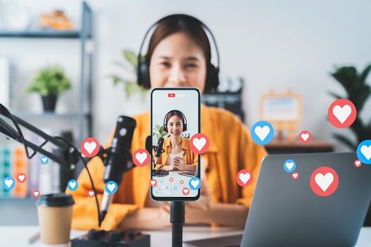 Content creator live streaming on a phone with likes floating around